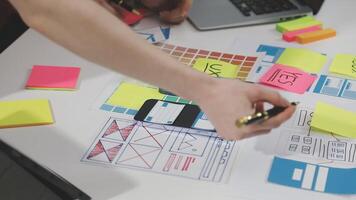 A person is using a laptop and a phone to make a design video