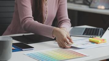 A woman is working on a computer with a color chart video