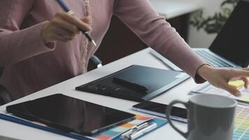 A woman is using a tablet to draw on a piece of paper video