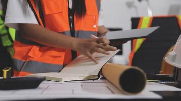 A woman in an orange vest and safety vest is working on a project video
