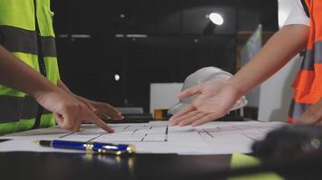 Two construction workers working on a blueprint video
