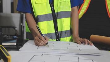 A construction worker is working on a blueprint video