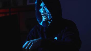hacker dentro face mascarar e moletom com capuz usando computador portátil dentro Trevas ilustrando identidade roubo e digital intrusão video