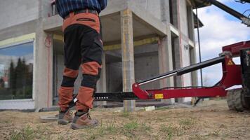 A man standing on a construction site with a red tractor video