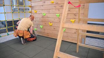 A man is working on a climbing wall video