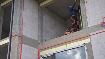 A man is standing on the side of a building video