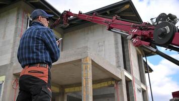 A man is standing on a construction site with a crane video