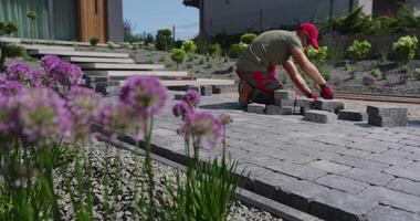 A man is working on a brick walkway video