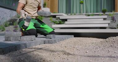 A man is working on a patio with bricks video