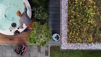 A man is standing in the middle of a backyard with a hot tub video