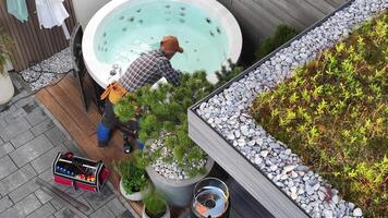 A man is working on a hot tub in a garden video
