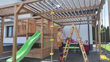 A wooden play structure with a slide and ladder video