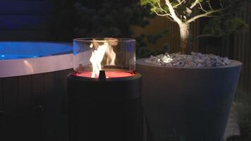 A fire in a glass container on a patio video