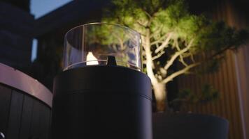 A lit candle is sitting on a table next to a tree video