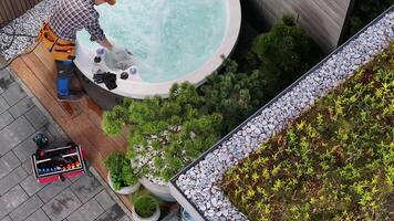 A man is working on a hot tub in a backyard video