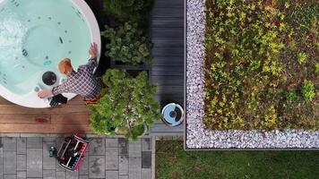 A man is sitting in a hot tub with a green roof video