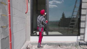 A man in red pants and a red hat is standing on a ladder video
