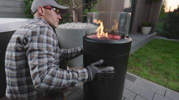 A man is putting a fire in a large outdoor fire pit video