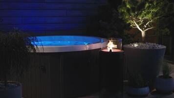A hot tub with a fire lit in the middle of the night video