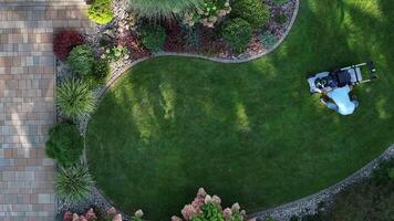 An aerial view of a lawn mower in a garden video