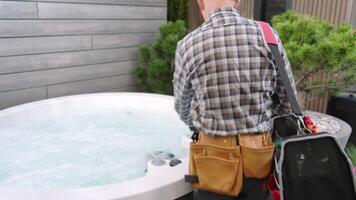 A man with a tool bag standing next to a hot tub video