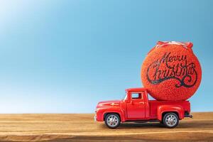 Christmas red retro car with a Christmas ball on a blue background photo
