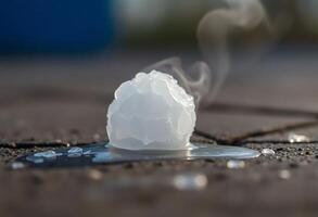 white substance floating on top of a puddle of water photo