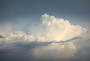 large cloud in the sky with a plane in the foreground photo