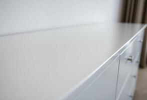 close up of a white counter top with a curtain in the background photo