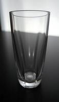 A glass with a white background sitting on a table photo