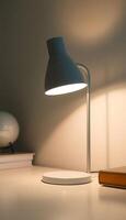 A desk lamp is on a table next to a book photo