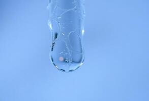A close up of a water drop on a blue background photo