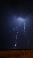 Lightning strikes over a field in the dark photo