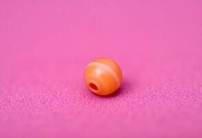 small orange object on a pink surface photo