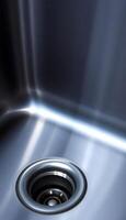close up of a metal sink with a drain photo