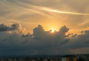 The sun is setting behind some clouds photo
