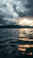 A view of the water at sunset with clouds photo