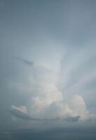 A plane flying through the sky with clouds in the background photo