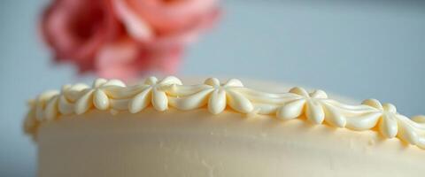 close up of a frosted cake with flowers in the background photo