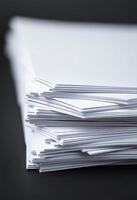 A stack of white paper on a black background photo
