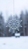 snowflake hanging from a string in the snow photo