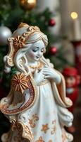 figurine of a woman with a christmas tree in the background photo