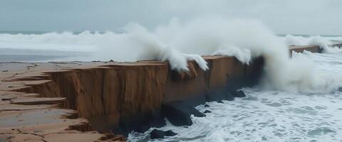 large wave crashes against a rock wall at the beach photo