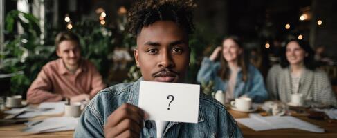 The young man holding a question mark card during a casual group discussion. photo