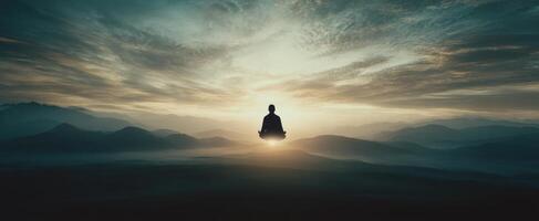 The serene figure meditating in a tranquil mountain landscape at sunrise. photo