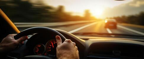 The person driving a car on a scenic highway during sunset photo