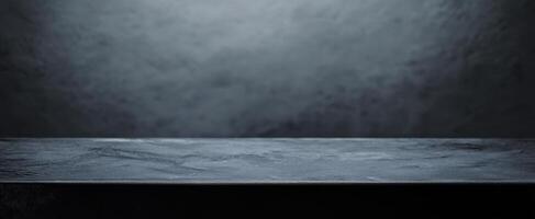 The sleek black tabletop with a dark textured background for photography. photo