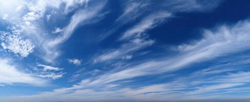 The serene sky filled with wispy clouds on a bright blue day. photo