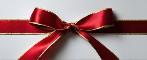 The elegant red and gold ribbon bow on a pristine background. photo
