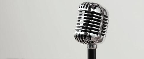 The vintage microphone standing elegantly against a plain background photo